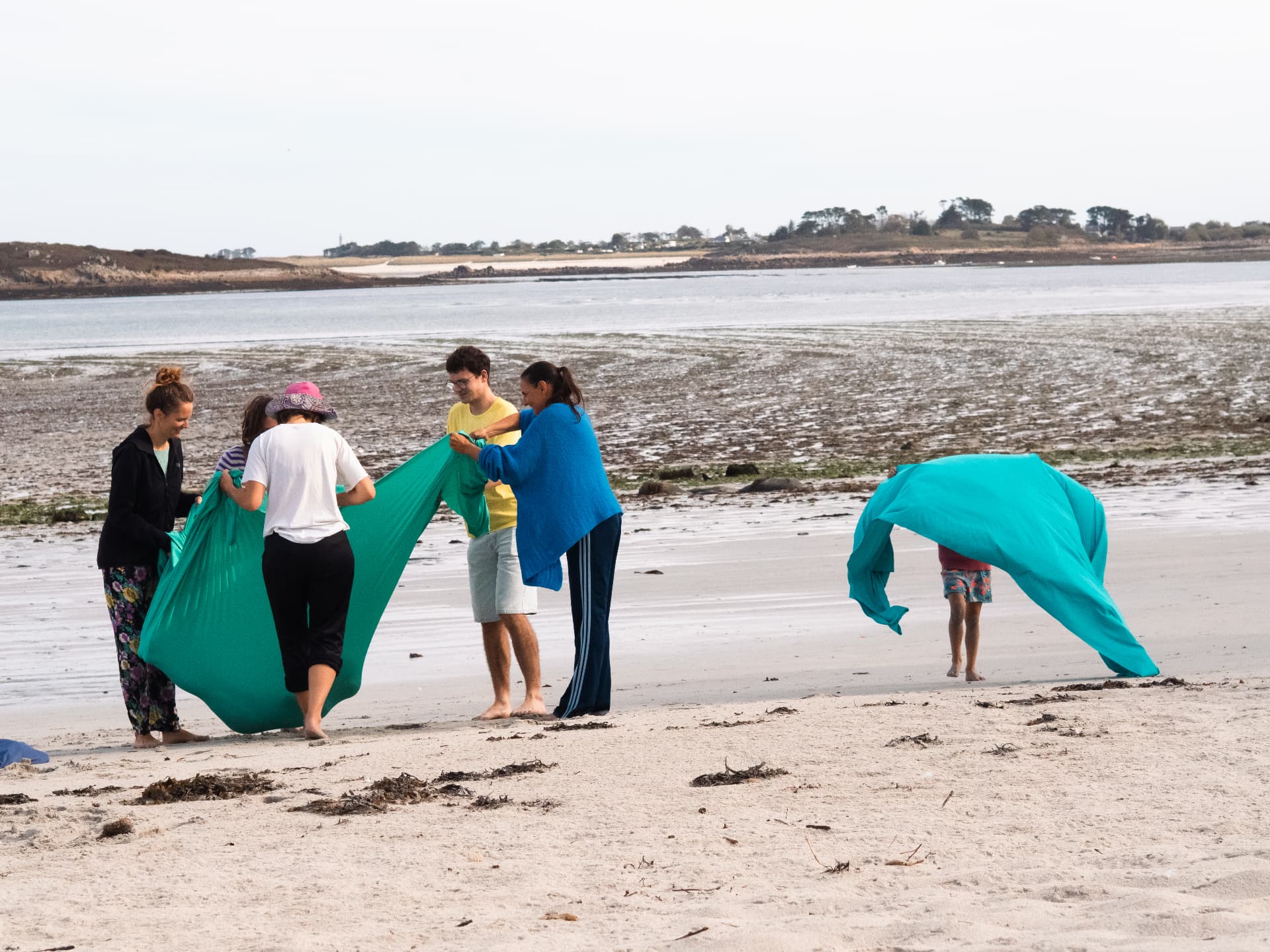 Tissus bleus et verts dans le vent sur la plage
