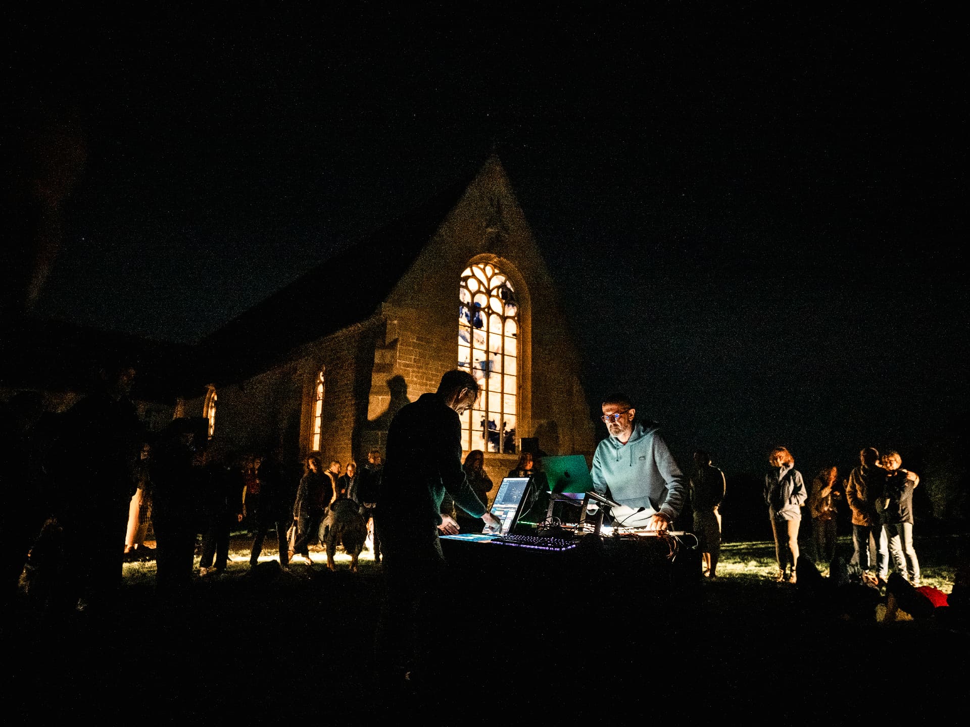 Musiciens électroniques devant la chapelle illuminée