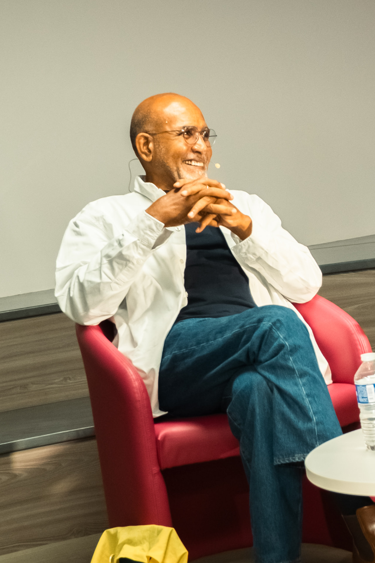 Patrick Chamoiseau souriant dans son fauteuil